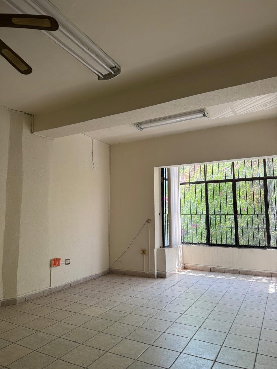 Oficina con ventana protegida y luminarias en el edificio de Monterrey