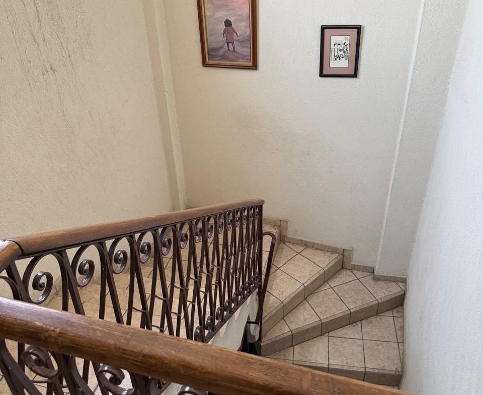 Escalera interior con barandal de madera del edificio en Monterrey