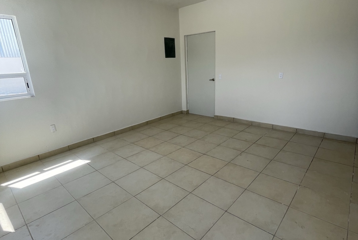 Interior de oficina con piso de loseta y ventana en la bodega de Derramadero