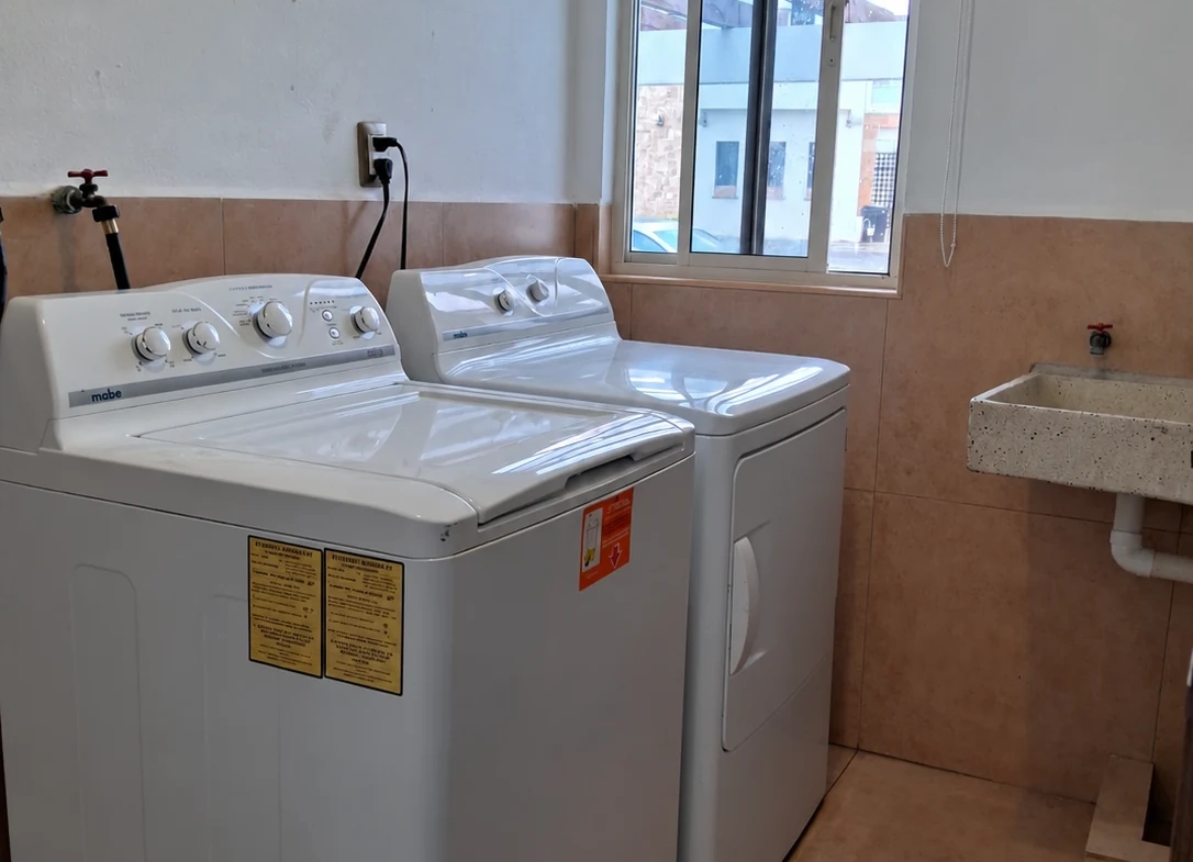 Área de lavado con lavadora, secadora y lavadero en la casa en Villas de Guadalupe