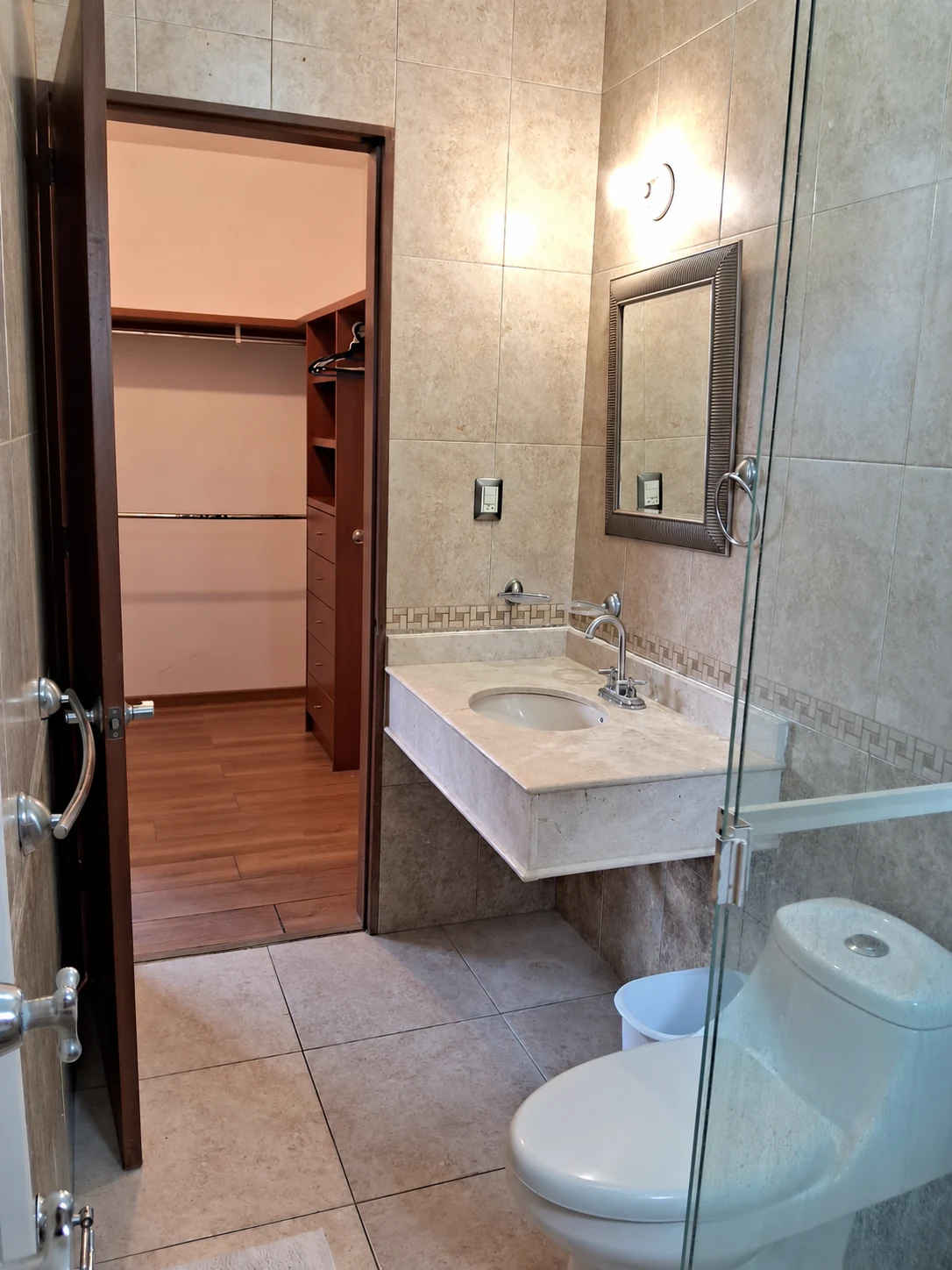 Casa en renta en Villas de Guadalupe, Saltillo – Baño y vestidor Baño con cancel de cristal, lavabo y acceso al vestidor de la casa en Saltillo